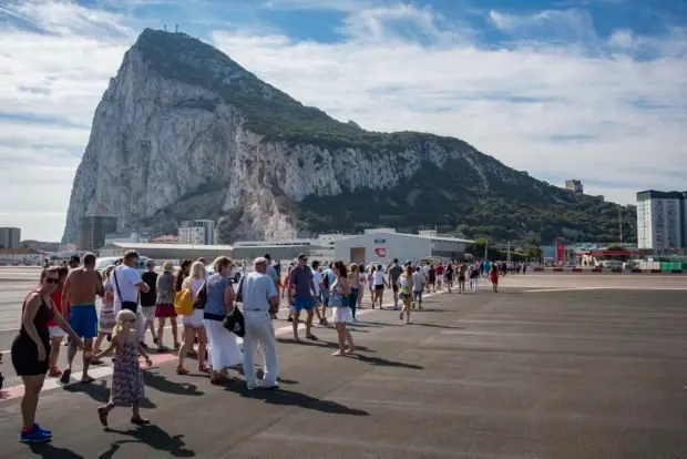 Hundreds of people cross the Gibraltar airport to go to National Day. National Day of Gibraltar before the Brexit, people go out to the street to celebrate it like every year. Casemates dresses in red and white. The Prime Minister of Gibraltar, Fabian Picardo and Teresa Mayer on the monitors give their speech to the Gibraltarians.