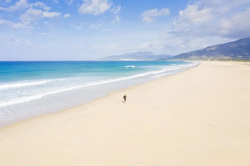 Person running along Los lances beach, Tarifa during the Covid 19 shutdown.