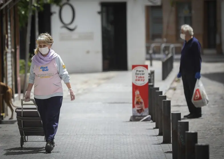 Una mujer camina con su mascarilla.