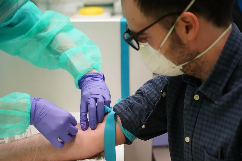 Un sanitario saca sangre a una persona.