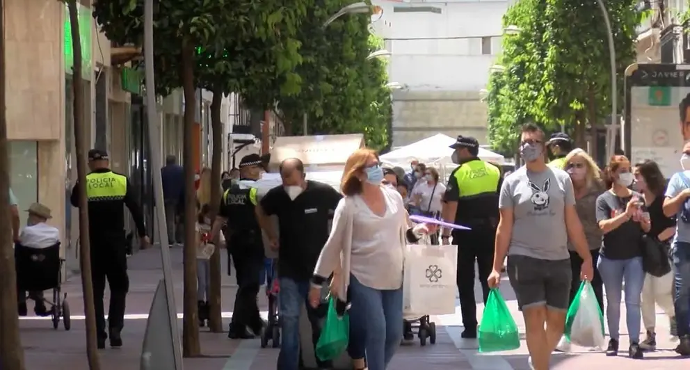 Gente paseando con mascarillas.