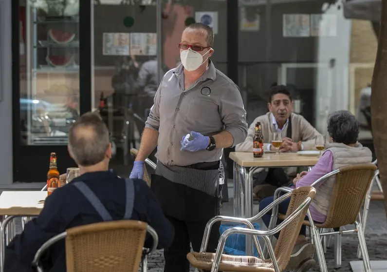 Un camarero atiende en una terraza