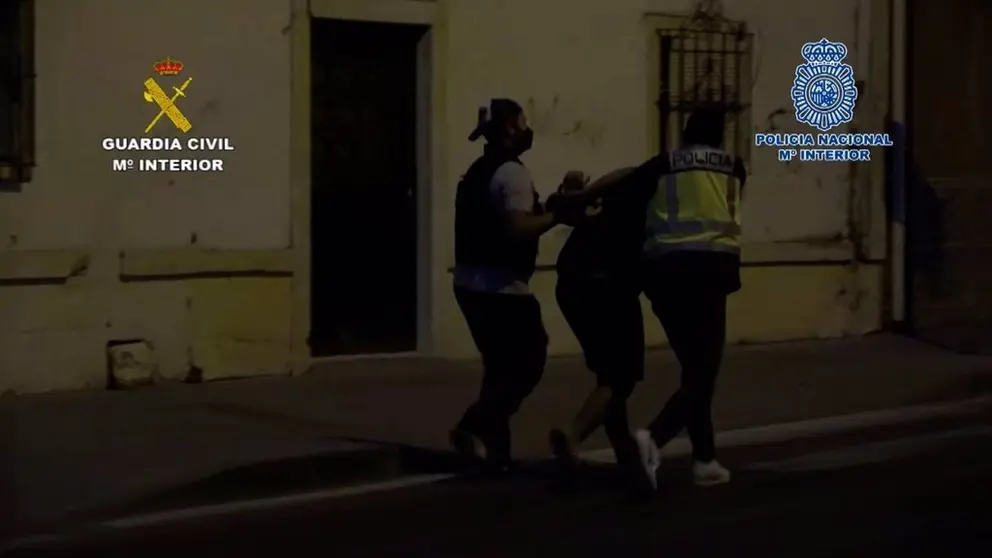 Agentes, con uno de los detenidos.