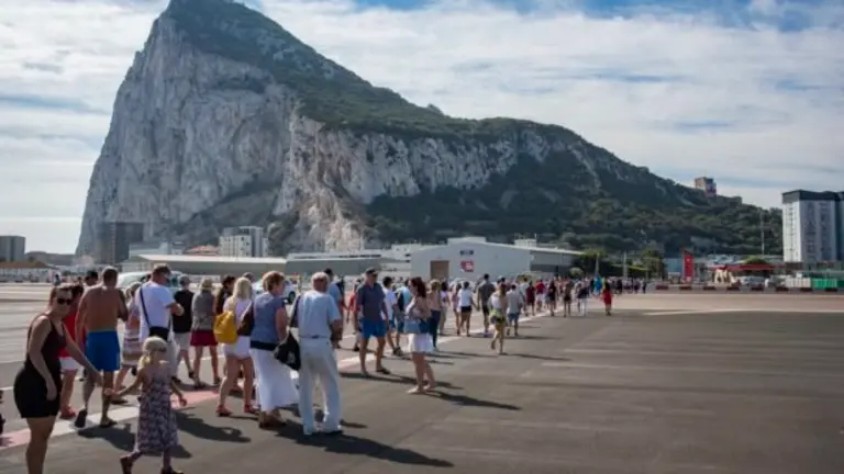 Hundreds of people cross the Gibraltar airport to go to National Day. National Day of Gibraltar before the Brexit, people go out to the street to celebrate it like every year. Casemates dresses in red and white. The Prime Minister of Gibraltar, Fabian Picardo and Teresa Mayer on the monitors give their speech to the Gibraltarians.