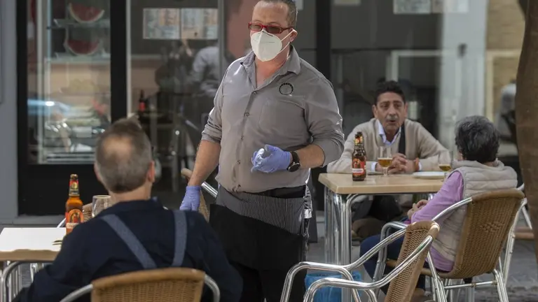 Un camarero atiende en una terraza